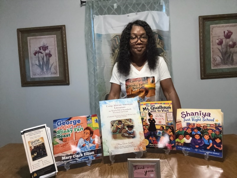 Mary Clark Elliott standing behind a display of her books